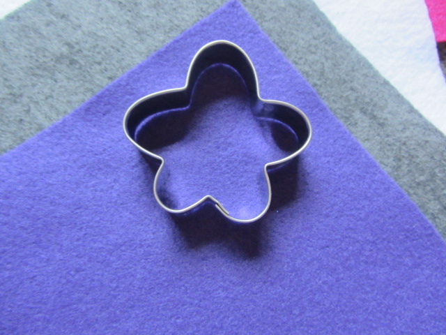I used a cookie cutter to cut my felt.  You could also freehand this.  I chose one that looked kind of like a flower.