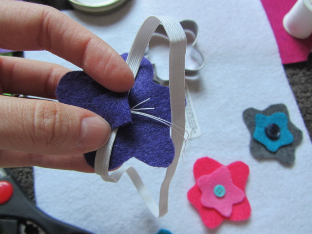 Sew the felt pieces with the button onto the elastic band.  Then cut out a small piece of felt to cover up the stitching on the inside of the headband to help protect your little one's delicate noggin.