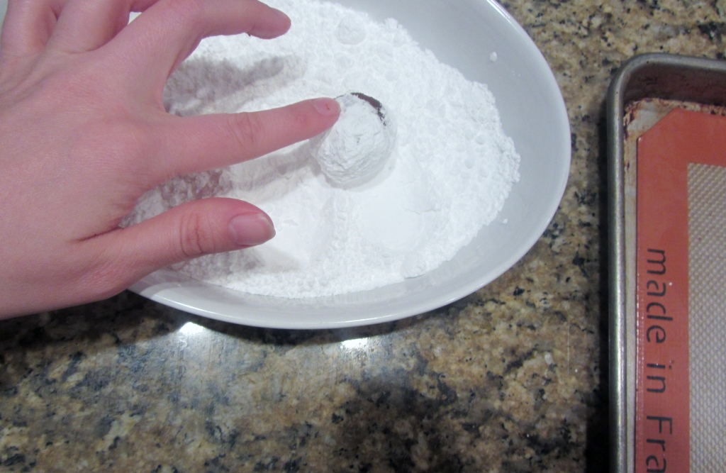 Roll the cookie dough balls in the powdered sugar.